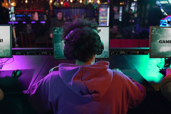 Achteraanzicht van een esports gamer die CS2 en Valorant speelt tijdens een bootcamp.