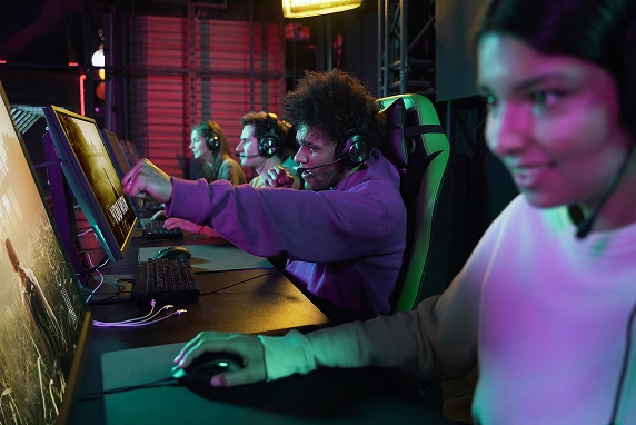 esports-spelers nemen deel aan een competitieve videogamewedstrijd, dragen headsets en zitten achter computers in een professioneel gamingcentrum met sfeervolle verlichting
